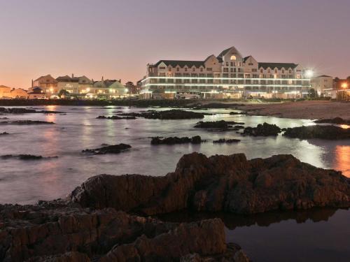 a large building on the beach at night at Krystal Beach Hotel in Gordonʼs Bay