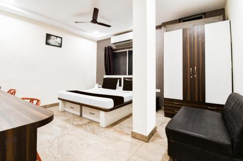 a bedroom with a bed and a couch in it at Hotel O Raipur City Center Formerly Hotel Edge in Raipur