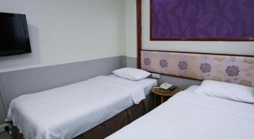 a room with two beds and a tv in it at Hotel 165 in Singapore