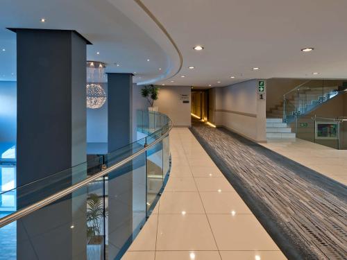 a hallway of a building with glass floors and stairs at Krystal Beach Hotel in Gordonʼs Bay