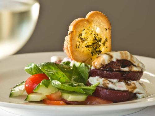 a plate of food with a sandwich and a salad at Krystal Beach Hotel in Gordonʼs Bay