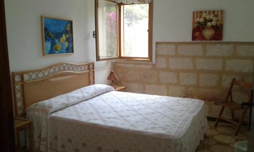 a bedroom with a bed and a window at VillA LA PinetA in Favignana