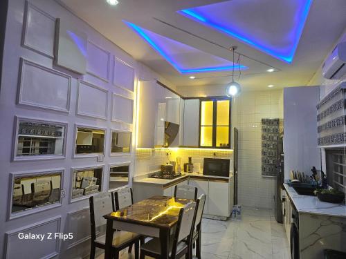 a kitchen with a table and a blue ceiling at Luxury 3 bed rooms villa in Lekki