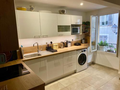 une cuisine avec un évier et une machine à laver dans l'établissement Au cœur du Vieux Nice, 3 chambres au calme, grand appartement, à Nice