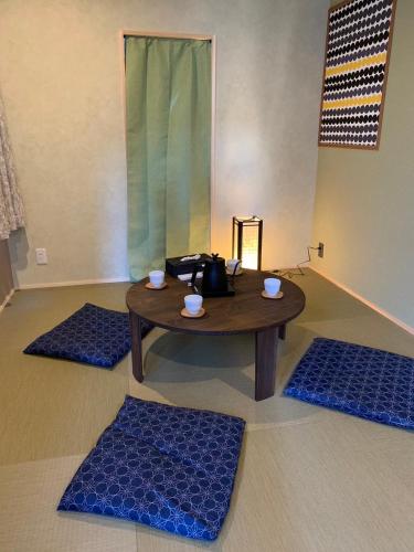 a room with a table and three blue mats at HOTEL PRELE Shinkan ホテルプレール新館 in Tokyo