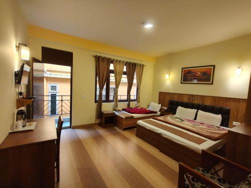 a bedroom with two beds and a balcony at Hotel Utpala in Gangtok