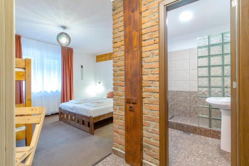 a room with a bedroom and a bathroom with a bed at Resort 7 Crai - Cabana Craiul Crailor in Zărneşti