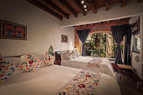 a bedroom with two beds and a window at Mesón De Leyendas Breakfast & Downtown in Valle de Bravo