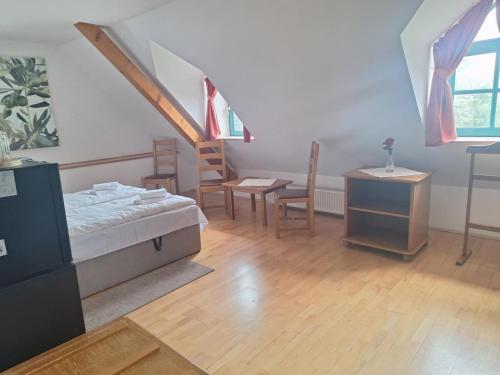 a bedroom with a bed and a table and chairs at Almási Öregmalom in Dunaalmás