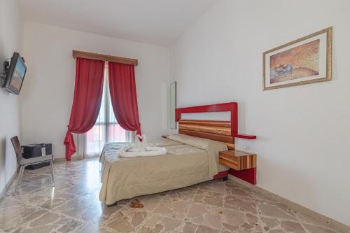 a bedroom with a bed with red curtains at diVino Hotel in Rilievo