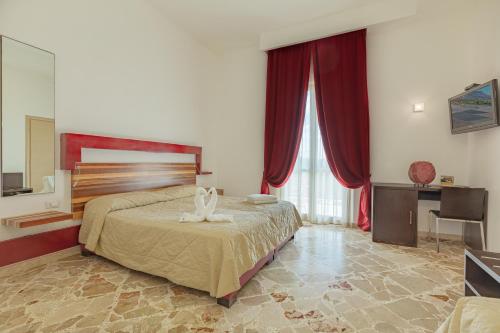 a bedroom with a large bed and red curtains at diVino Hotel in Rilievo