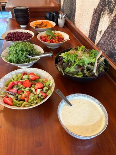 a wooden table topped with bowls of food and salads at Familiehotel La Randulina in Ramosch