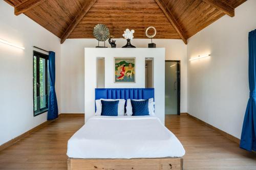 a bedroom with a large bed with blue accents at CASA DIOS Luxury Villas in Khandala