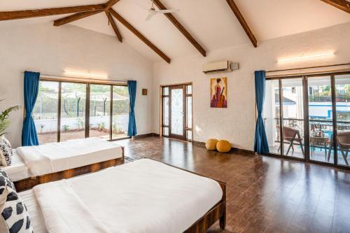 a large room with two beds and a balcony at CASA DIOS Luxury Villas in Khandala