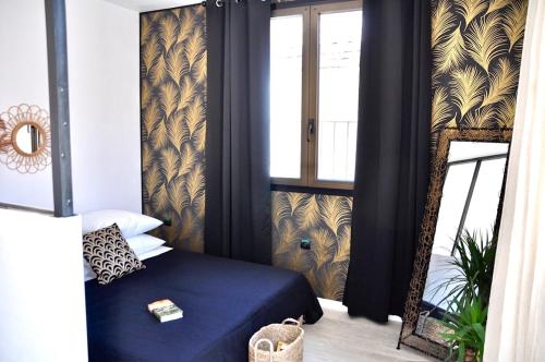 une chambre avec un lit bleu et un miroir dans l'établissement Ma pause en Provence, à LʼIsle-sur-la-Sorgue