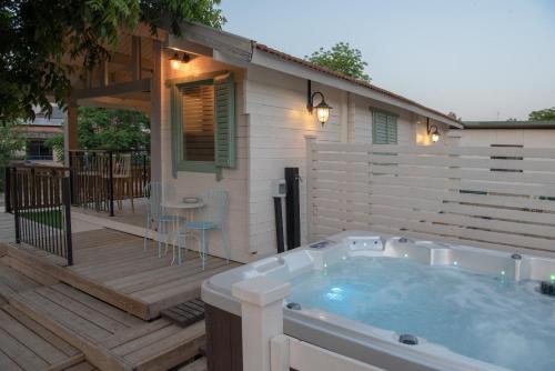 a hot tub on a deck next to a house at הבקתה של רינת in Me‘ona