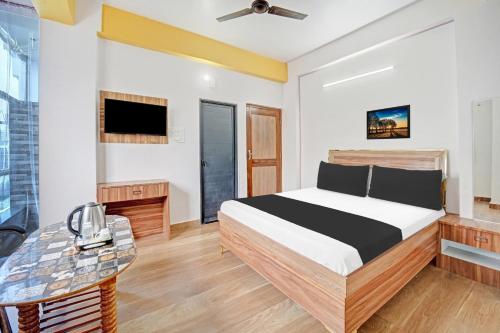 a bedroom with a bed and a tv at Hotel O Arvind Inn in Patna