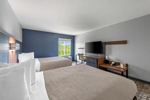 a hotel room with two beds and a flat screen tv at Quality Inn & Suites Manhattan in Manhattan