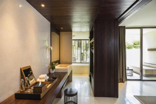 a living room with a table and a large window at Alila Seminyak in Seminyak