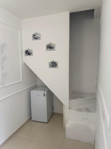 a white room with a staircase and a refrigerator at casa effe 2 in Naples