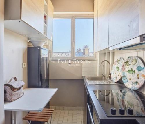 une cuisine avec un évier et un plan de travail dans l'établissement Pont de neuilly, à Neuilly-sur-Seine