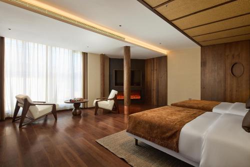 a bedroom with a bed and a table and chairs at ARULA J Hotel in Lijiang