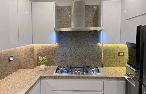 a kitchen with a stove and a counter top at شقة فاخرة 3 غرف نوم و حديقة خاصة في الشيخ زايد - Zayed Suites A in Sheikh Zayed