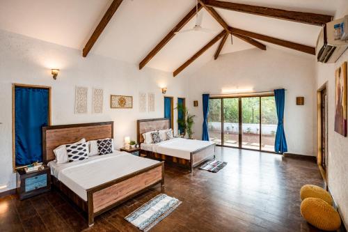a bedroom with two beds in a room with blue curtains at CASA DIOS Luxury Villas in Khandala