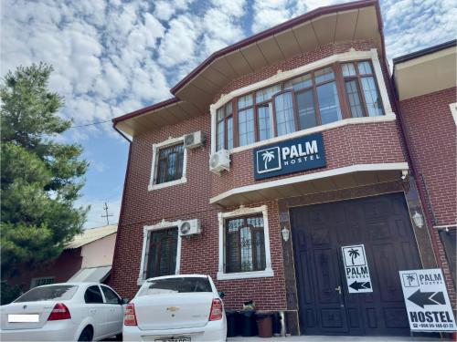a building with cars parked in front of it at Palm Hostel in Tashkent