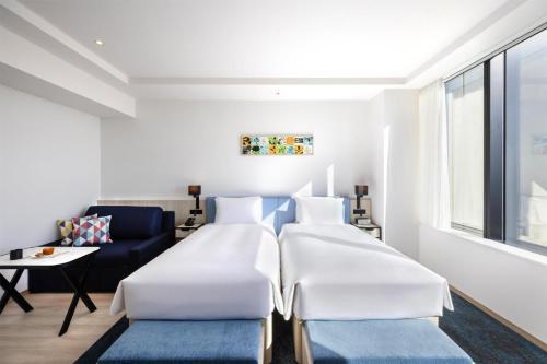 a bedroom with two beds and a couch at Hyatt House Tokyo Shibuya in Tokyo