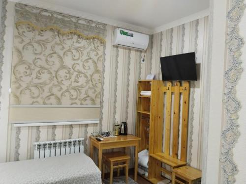 una camera da letto con un letto e una TV a parete di Hotel Allanazar Ota a Khiva