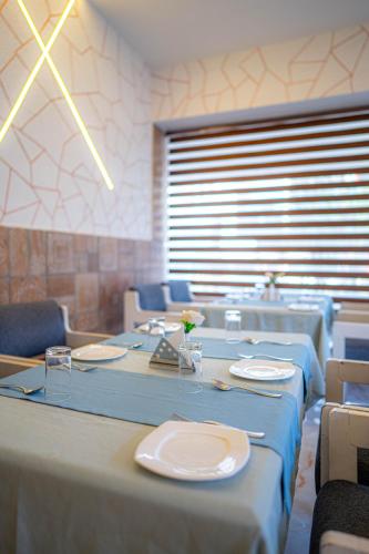 a dining room with tables and chairs with blue tablecloths at Casino Hotels Ltd in Trichūr