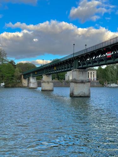 un pont sur l'eau avec un train sur l'eau dans l'établissement La cabine, à Saint-Cloud
