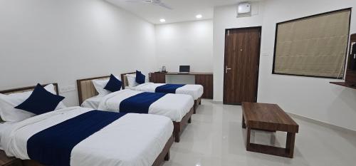 a hotel room with three beds and a flat screen tv at Daze Off Studio house in Bhuj
