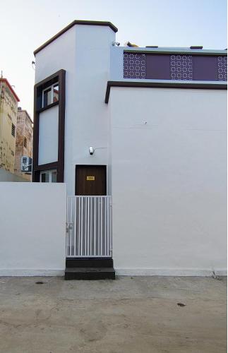 a white building with a door and a window at Daze Off Studio house in Bhuj