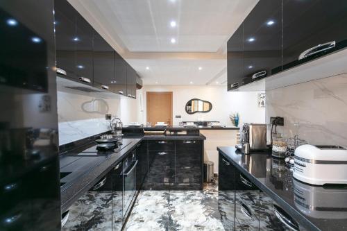 a kitchen with black and white counter tops at Résidence Coralia, piscine, fibre obtique, Parking gratuit in Marrakech