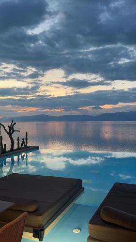 a swimming pool with a view of the water at ​Le Grand Bleu Resort in Derveni