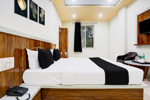 a bedroom with a white bed and a desk at Hotel O Shree Palace in Udaipur