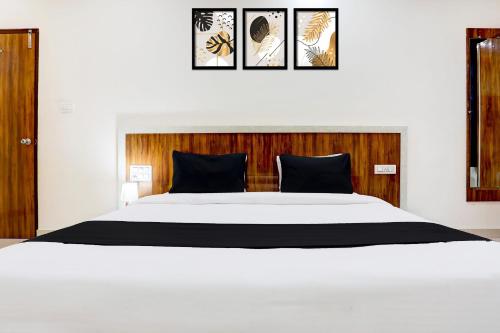 a bedroom with a white bed with four pictures on the wall at Hotel O Shree Palace in Udaipur