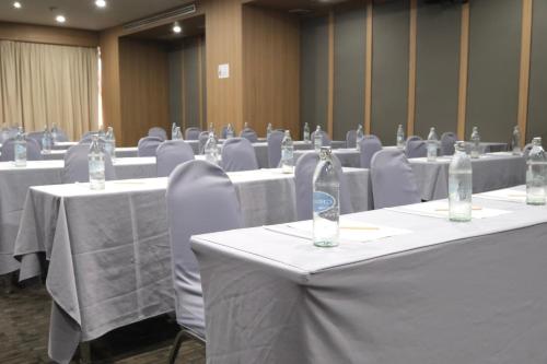 a conference room with white tables and chairs with water bottles at Le cassia Hotel in Khon Kaen