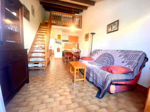 un salon avec un canapé et un escalier dans l'établissement Maisonnette 6 personnes proche plage – Animaux acceptés, au Grau-du-Roi