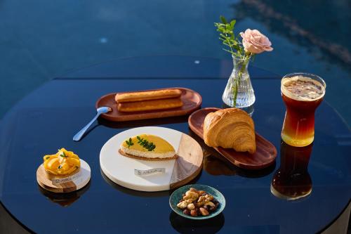 a blue table with a plate of food and a drink at ARULA J Hotel in Lijiang