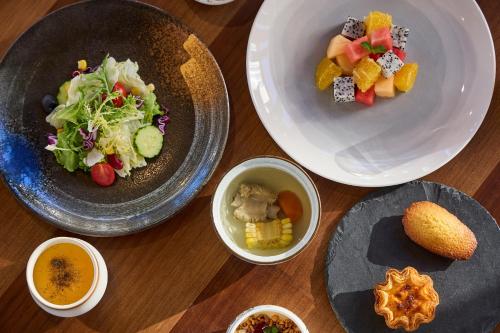 a table topped with plates of food and bowls of food at ARULA J Hotel in Lijiang