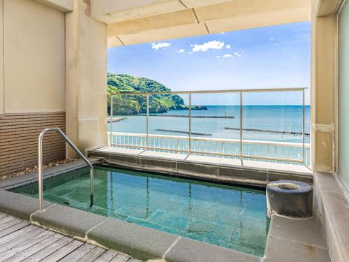 a swimming pool with a view of the ocean at 公共の宿伊豆まつざき荘 in Matsuzaki