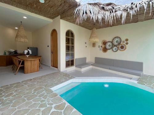 a swimming pool in the middle of a room with a table at Tujuan Jogja Villas - Kresna in Yogyakarta