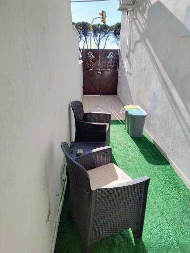 two chairs and a table on a balcony with green grass at Al VICO TREDICI in Gaeta