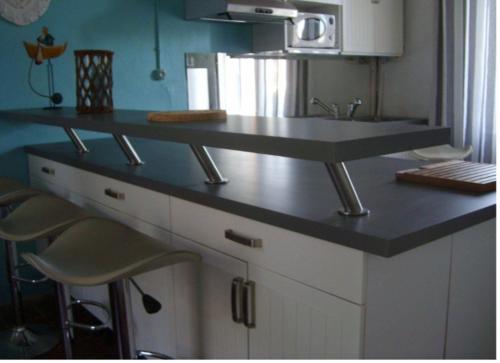 une cuisine avec un comptoir, un évier et des tabourets dans l'établissement Charmante maison dans le centre d'Olonne sur mer, à Les Sables-dʼOlonne
