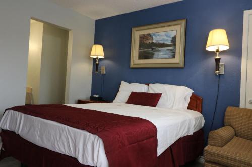 a bedroom with a large bed with a blue wall at American Star Inn - Abilene in Abilene