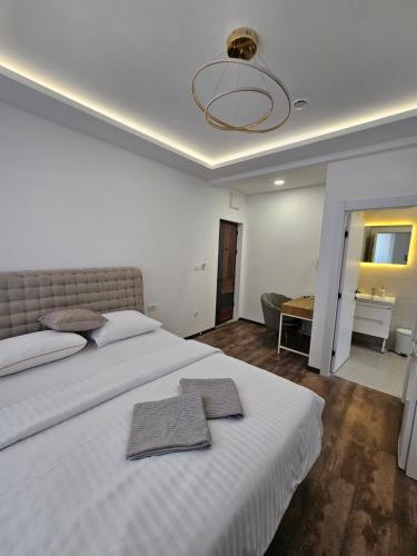 a bedroom with a large white bed with towels on it at La Vida Apartments in Babalonija