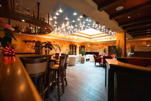 a restaurant with a bar with chairs and tables at Hotel Hochsauerland 2010 in Willingen